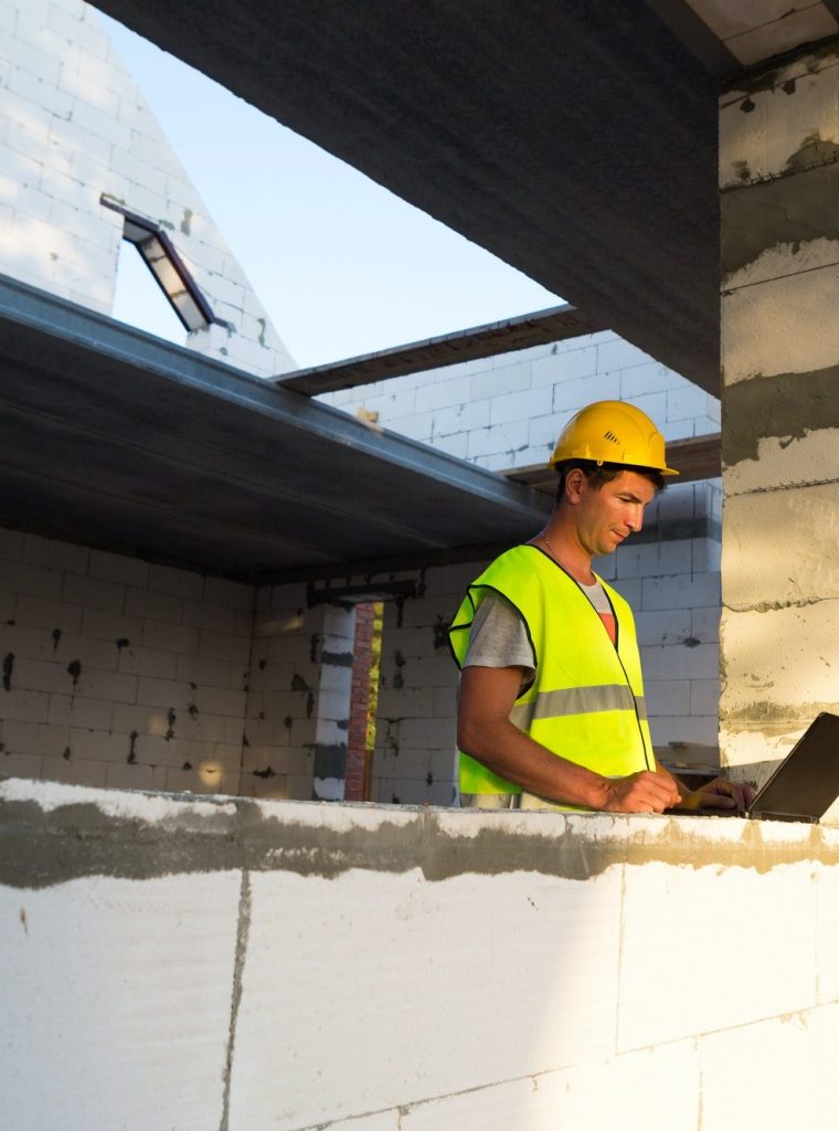 Construction engineer on the construction site of a house made of porous concrete blocks